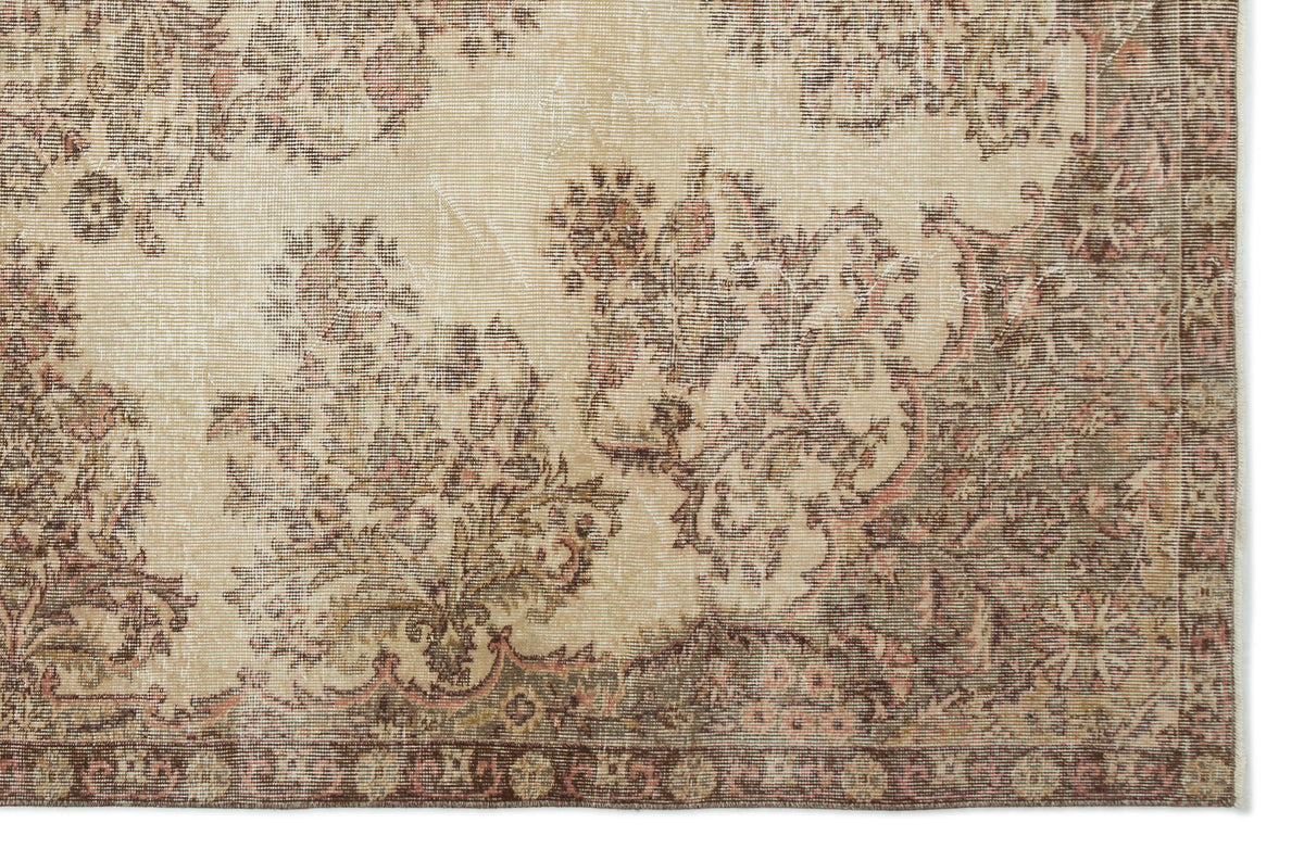 Beige and brown vintage-style rug with a distressed floral medallion pattern and a decorative border.