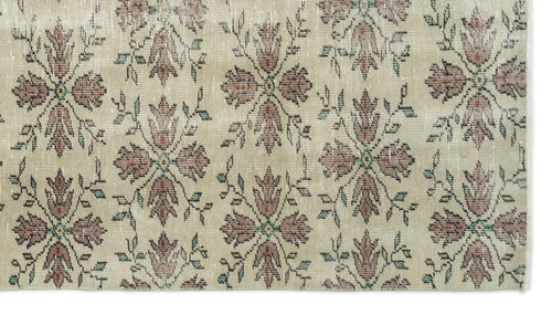 Load image 1 in gallery view. Beige rug with a repeating floral medallion pattern in muted red and green tones.