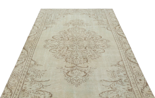 Load image 1 in gallery view. Beige and taupe vintage-style rug with a central floral medallion and ornate border on a white background.