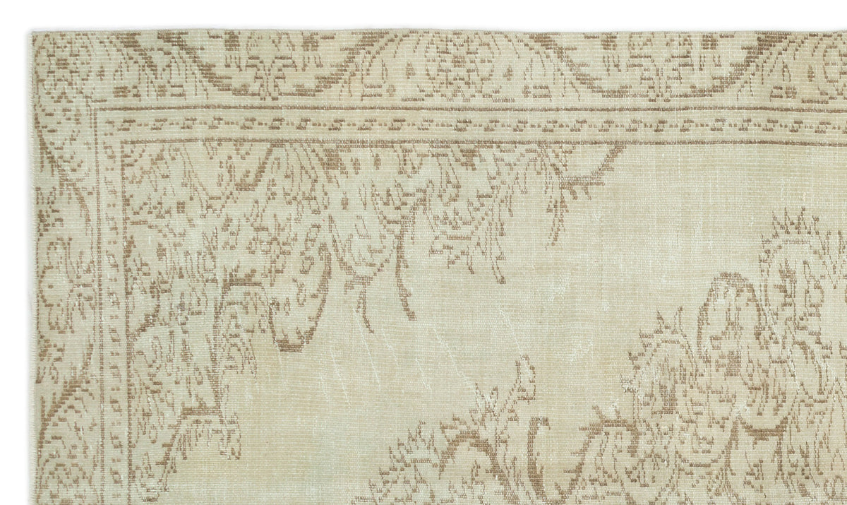 Beige and taupe rug with a distressed traditional floral medallion pattern and a linear border.