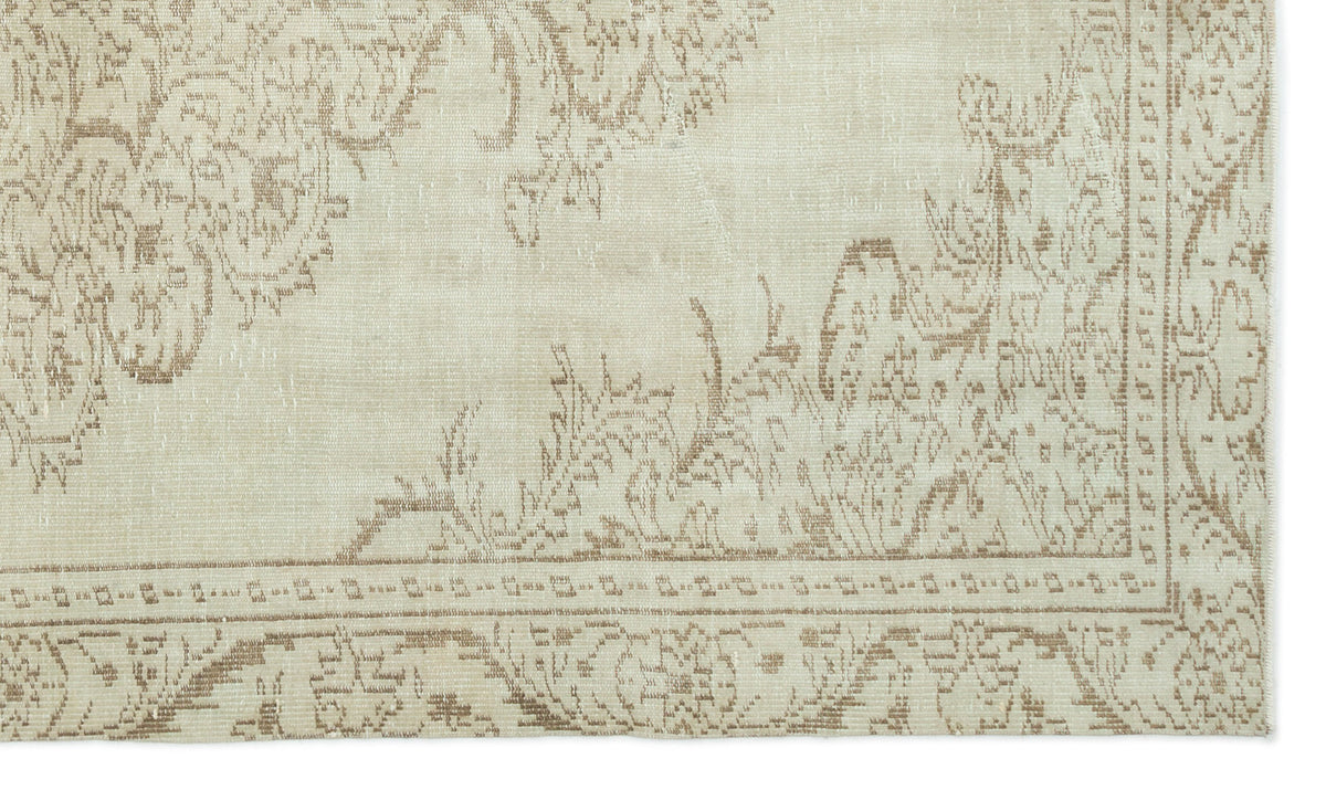 Beige and taupe rug with a faded traditional floral medallion pattern and a geometric border.