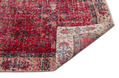 Load image 1 in gallery view. Distressed red Persian-style rug with blue and cream floral patterns and a folded corner on a white background.
