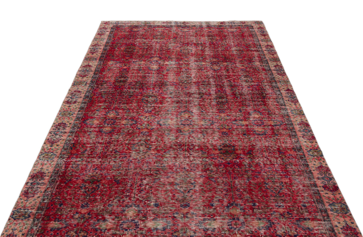 Distressed red vintage-style rug with a faded traditional medallion pattern and intricate floral borders.
