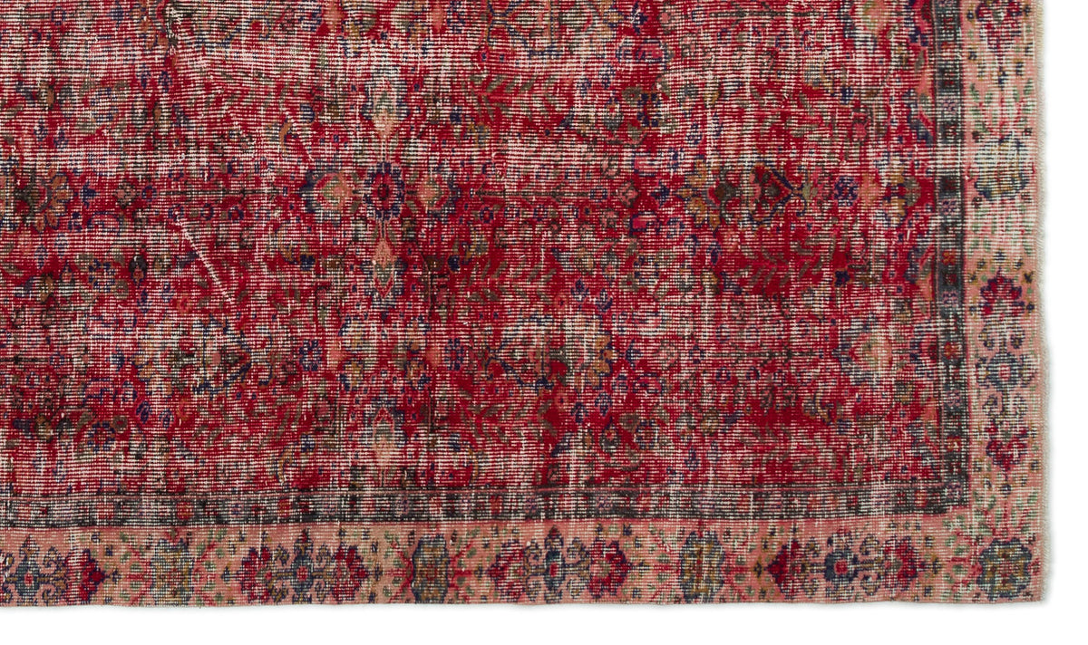 Distressed red vintage-style rug with a faded floral medallion pattern and a contrasting pink and dark grey border.