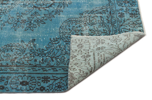 Load image 1 in gallery view. Distressed teal rug with a black floral medallion pattern, showing the woven underside at the folded corner.