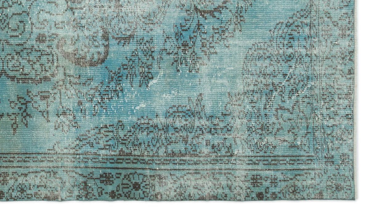 Distressed turquoise and charcoal rug with a faded traditional floral medallion pattern.