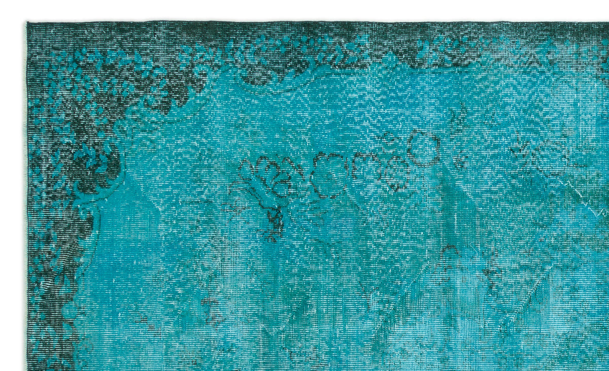 Teal and dark green distressed rug with a faded traditional floral medallion pattern.