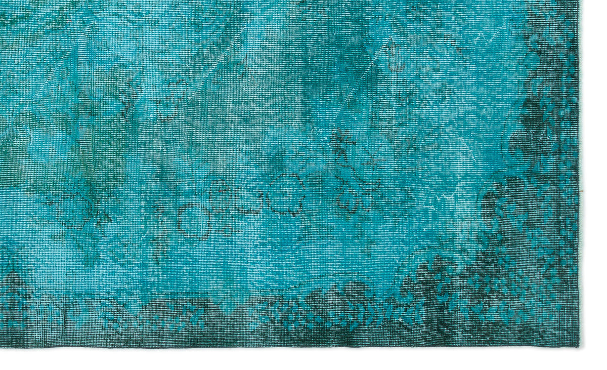 Teal and dark green distressed vintage rug with a faded traditional floral medallion pattern.