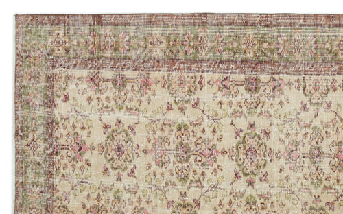 Load image 1 in gallery view. Distressed beige rug with a faded floral medallion pattern in muted pink, green, and brown tones.