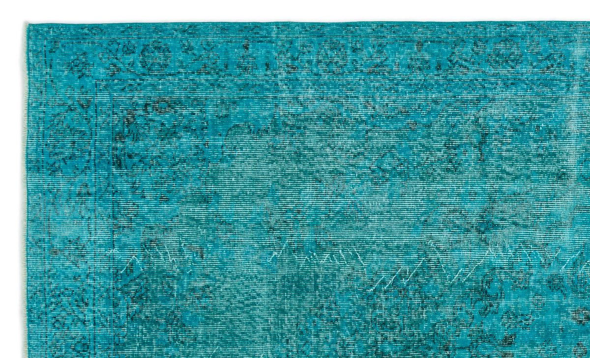 Teal distressed rug with a faded traditional floral medallion pattern and a bordered edge.