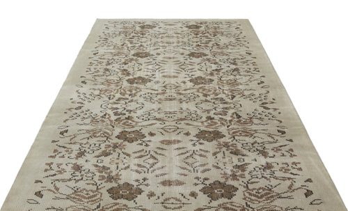 Load image 1 in gallery view. Beige and brown vintage-style rug with a distressed floral and geometric pattern on a white background.