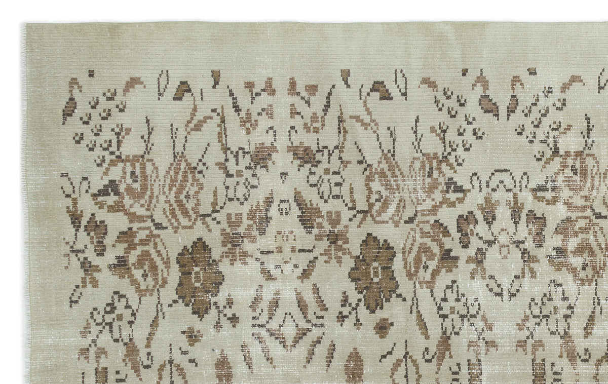 Beige rug with a distressed brown floral medallion pattern and a textured, low-pile weave.