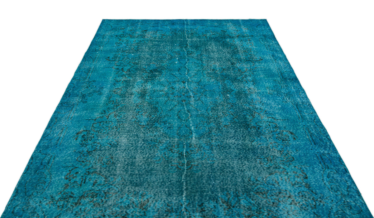 Teal distressed area rug with a faded traditional medallion pattern on a white background.