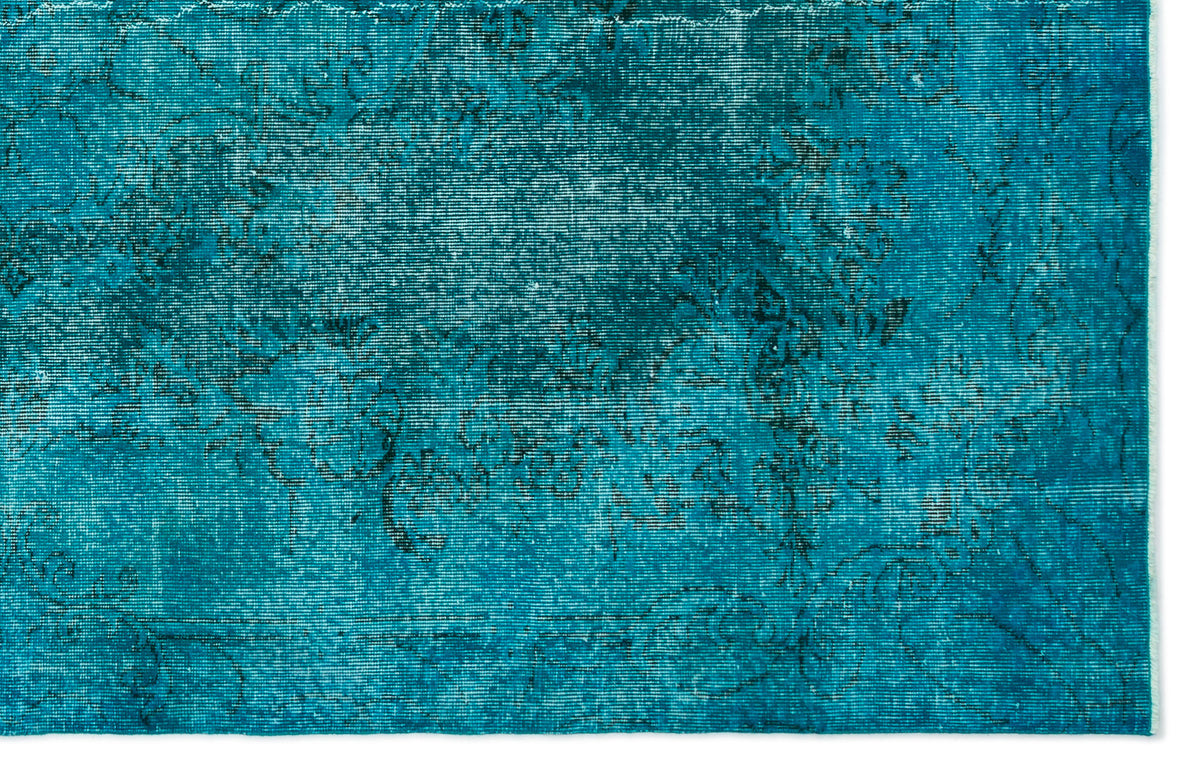Teal distressed rug with a faded black traditional floral medallion pattern on a white background.