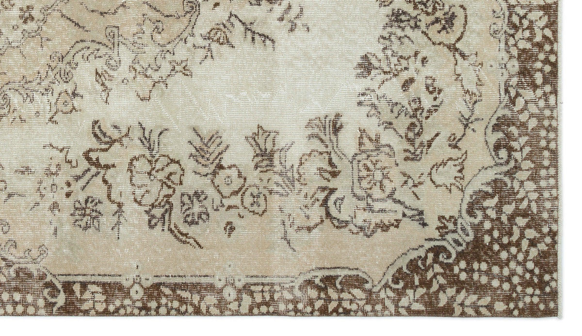 Beige and brown rug with a distressed floral medallion pattern and a detailed border.