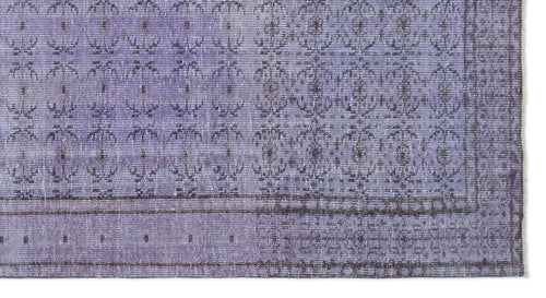 Load image 1 in gallery view. Lavender and dark purple distressed rug with a repeating floral medallion pattern and a bordered edge.