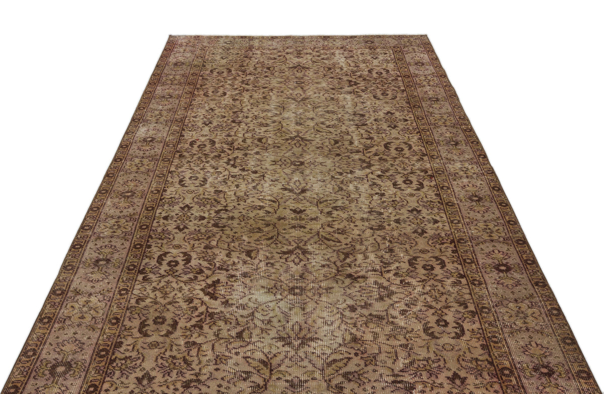 Distressed brown and tan vintage-style rug with an all-over floral medallion pattern and a detailed border.