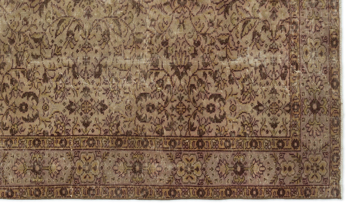 Distressed brown and taupe rug with a traditional floral medallion pattern and a detailed border.