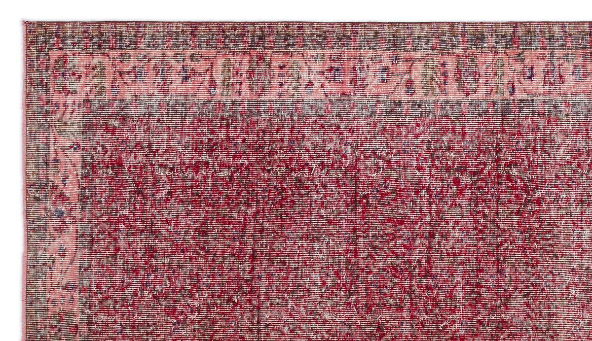 Distressed deep red and pink vintage-style rug with a dark border and faded floral motif.