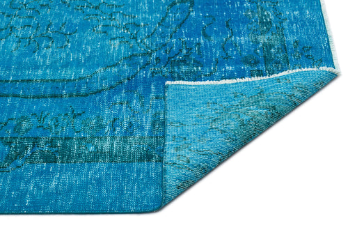Load image 1 in gallery view. Bright blue distressed rug with a faded traditional pattern and a folded corner showing the underside.