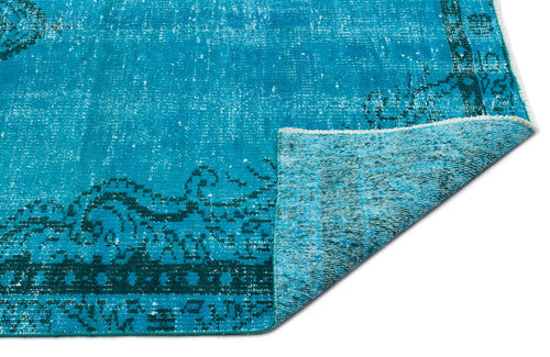 Load image 1 in gallery view. Bright turquoise distressed rug with a dark teal traditional border pattern, shown with a folded corner on white.