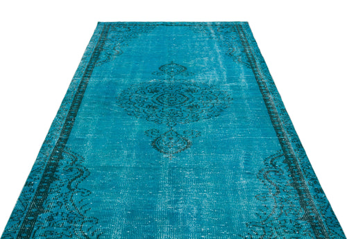 Load image 1 in gallery view. Bright turquoise distressed rug with a dark charcoal central medallion and ornate border pattern on a white background.