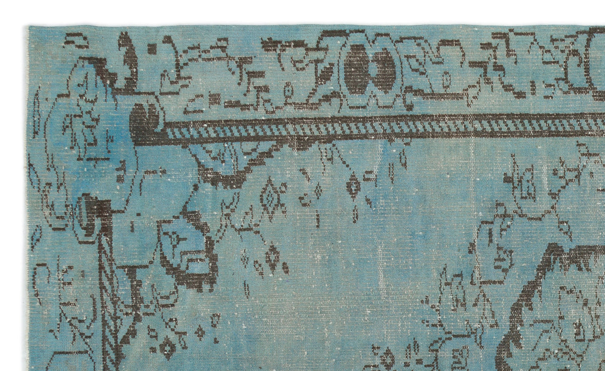 Distressed turquoise rug with a dark charcoal geometric border and abstract, faded traditional motifs.