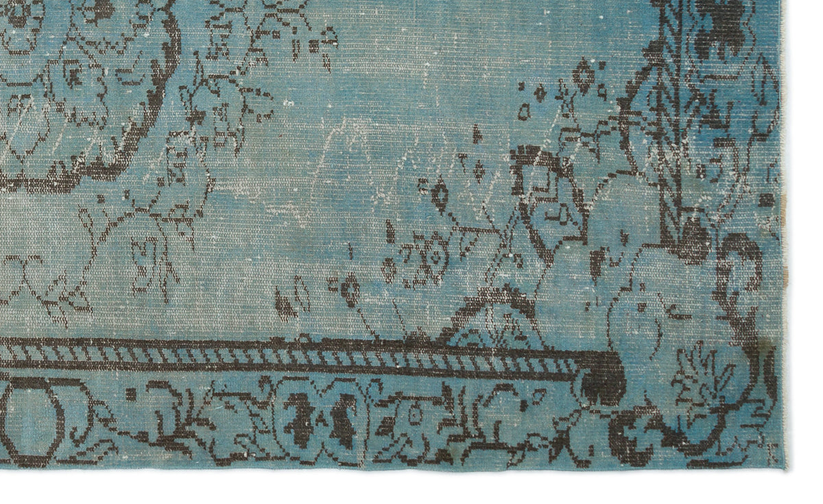 Distressed turquoise rug with a dark charcoal floral medallion pattern and a linear border.