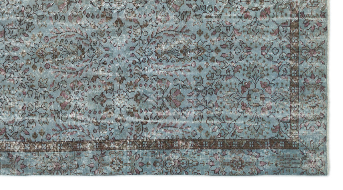 Light blue traditional rug with a distressed floral pattern in brown and muted pink, featuring a dark border.