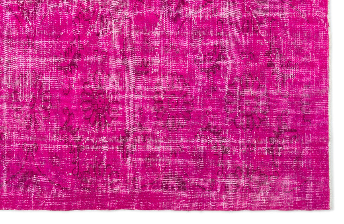 Vibrant magenta distressed rug with a faded traditional floral medallion pattern.