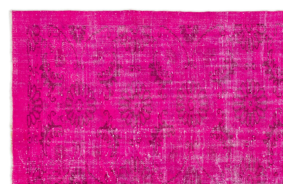 Hot pink distressed vintage-style rug with a faded dark floral medallion pattern.