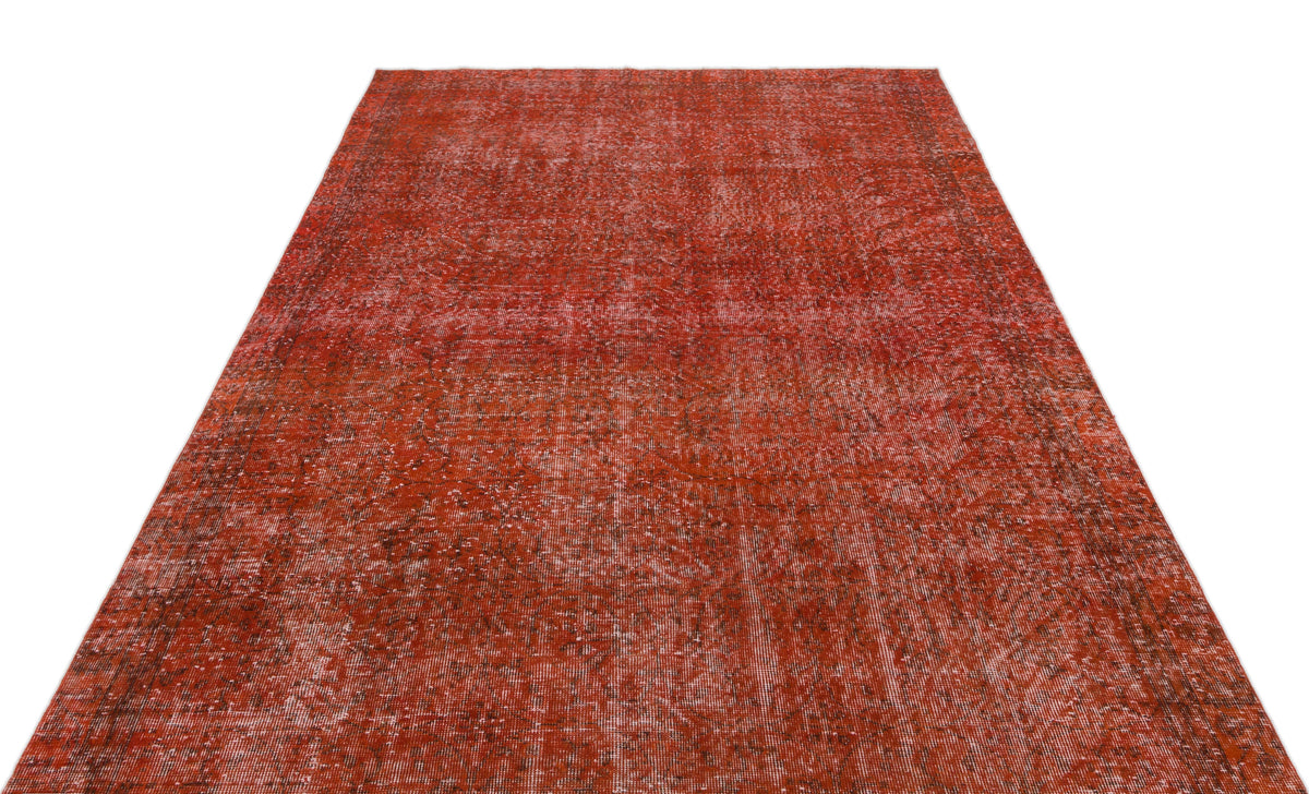 Distressed terracotta red vintage-style rug with a faded, intricate traditional pattern on a white background.