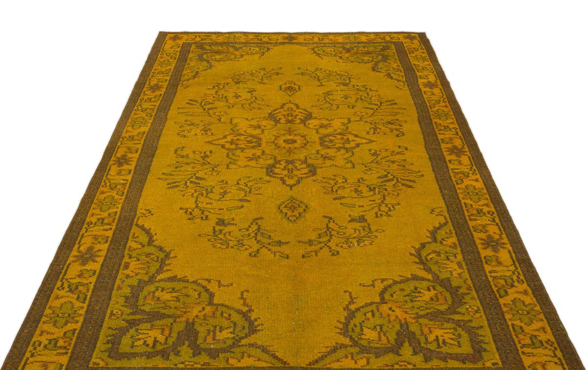 Mustard yellow and brown traditional rug with a central floral medallion and ornate border on a white background.