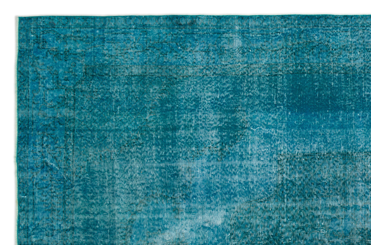 Teal distressed overdyed rug with a faded, textured vintage pattern.
