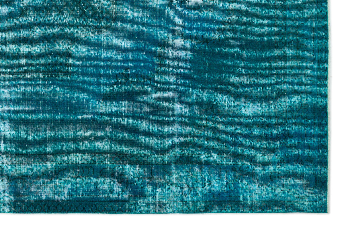 Teal and blue distressed rug with a faded, overdyed vintage pattern.