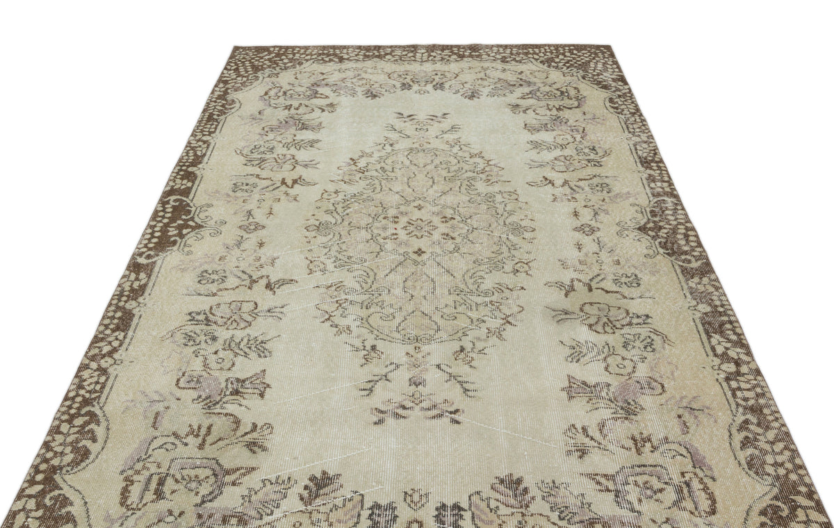 Beige and brown vintage-style rug with a central floral medallion and ornate border on a white background.