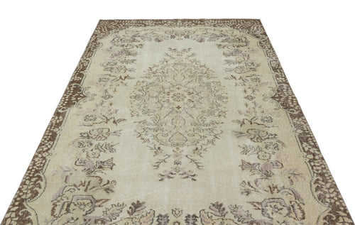 Load image 1 in gallery view. Beige and brown vintage-style rug with a central floral medallion and ornate border on a white background.