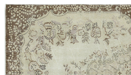 Load image 1 in gallery view. Beige and brown vintage-style rug with a distressed floral medallion pattern and a decorative border.