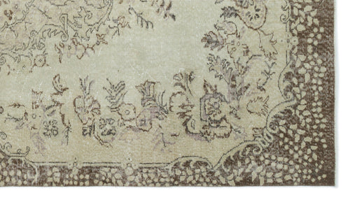 Load image 1 in gallery view. Beige and brown distressed rug with a traditional floral medallion pattern and a wide decorative border.