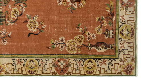 Load image 1 in gallery view. Terracotta rug with yellow floral branches and a cream border featuring geometric and botanical motifs.