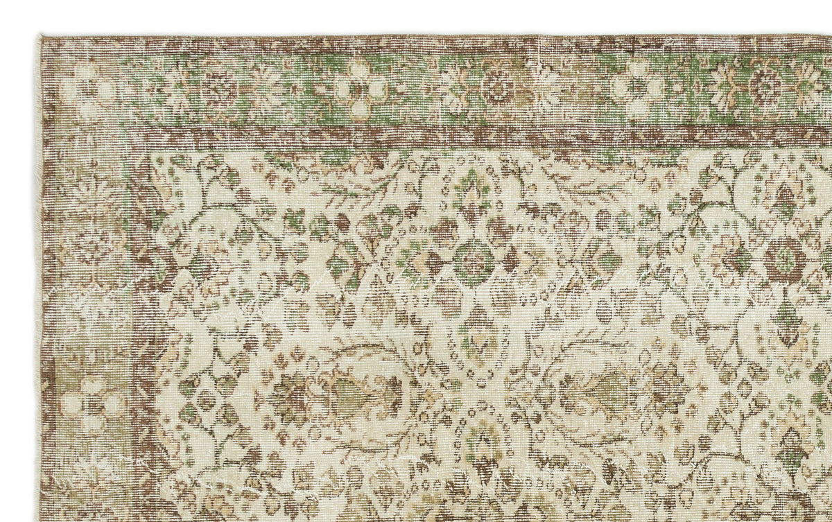 Cream, brown, and sage green vintage-style rug with a traditional floral medallion pattern and a decorative border.