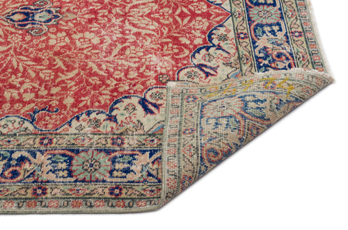 Load image 1 in gallery view. Red and cream traditional Persian-style rug with blue floral borders and a folded corner showing the underside.