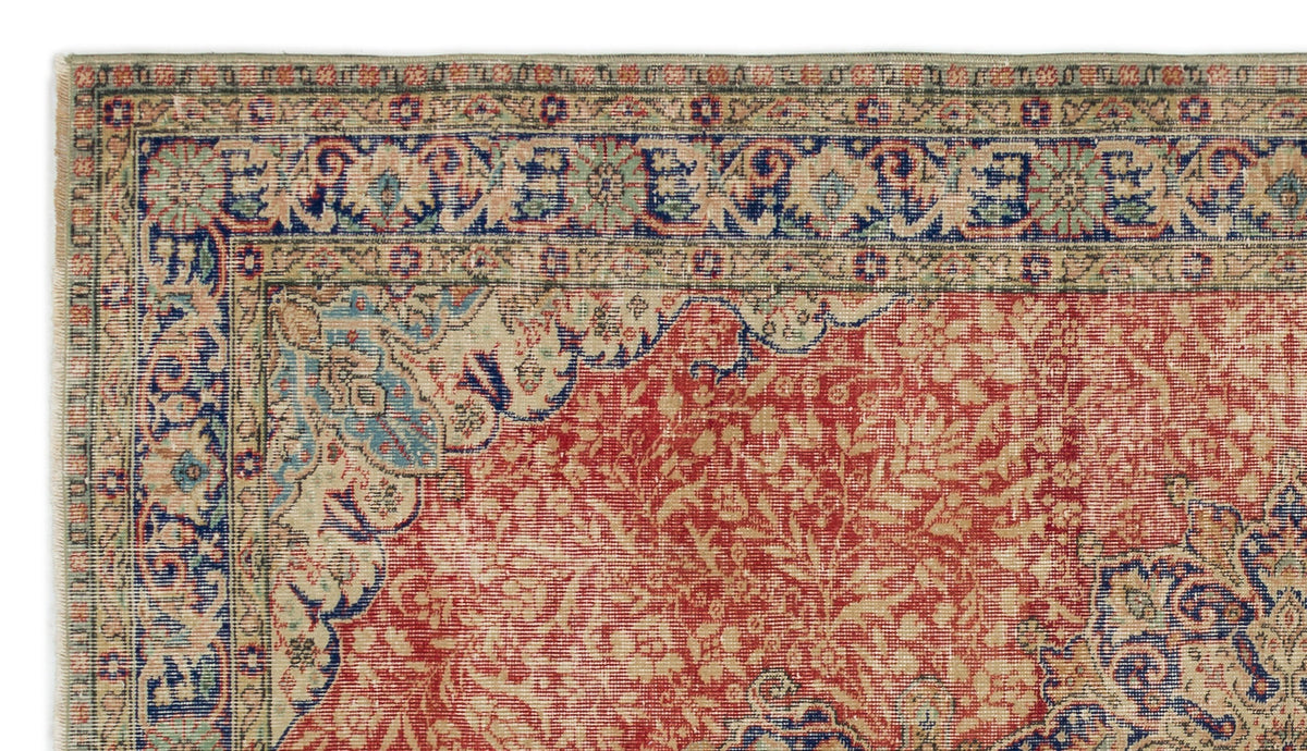 Red, blue, and beige traditional Persian-style rug with a dense floral pattern and intricate multi-layered border.
