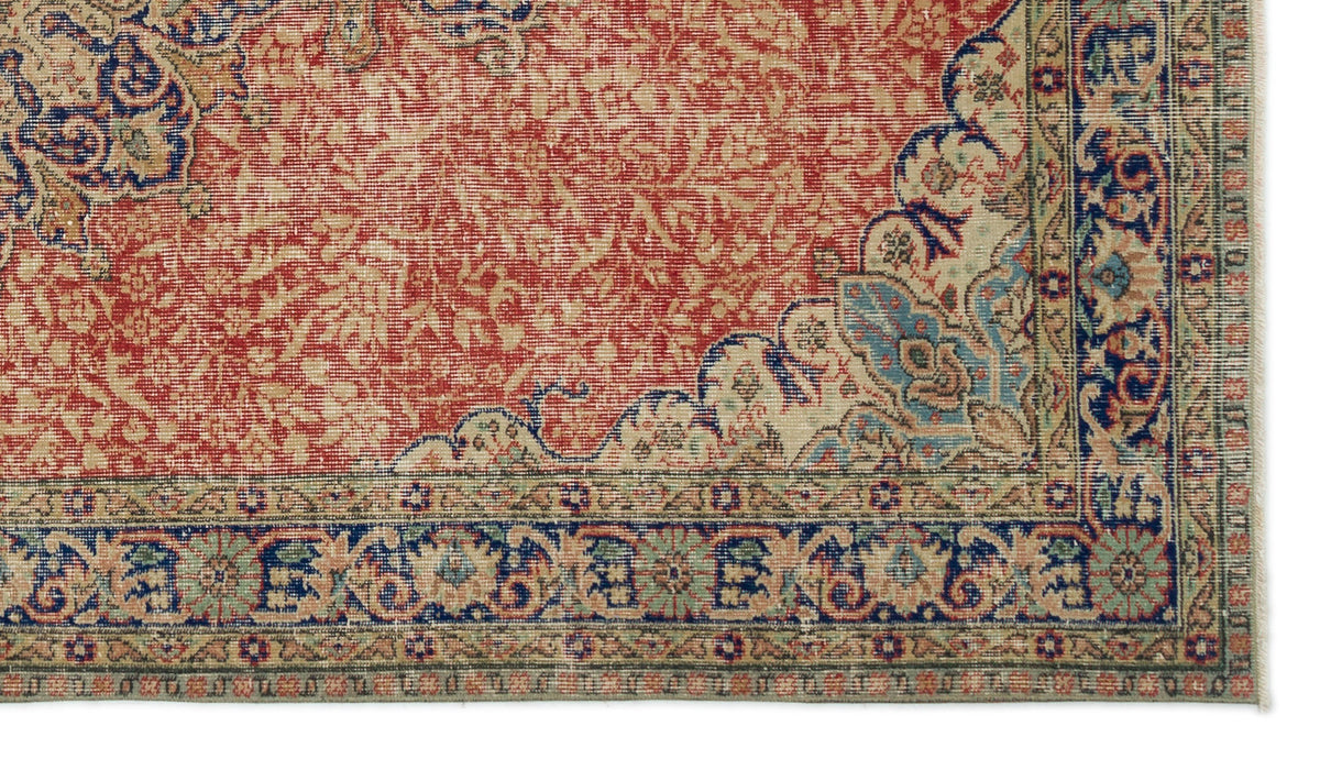 Red and cream traditional rug with a distressed floral medallion pattern and a blue and green geometric border.