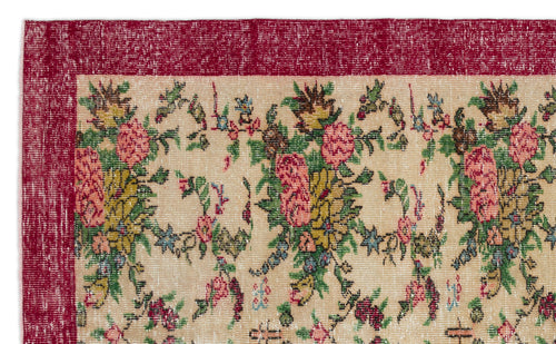 Load image 1 in gallery view. Distressed beige rug with a deep red border and a repeating floral pattern in pink, green, and yellow.