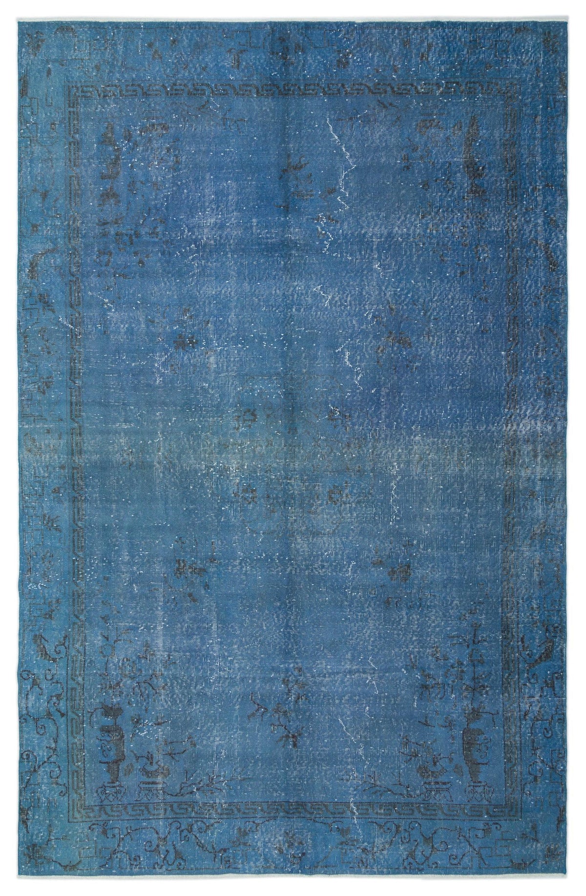 Distressed blue rug with a faded traditional border and central floral motif on a white background.