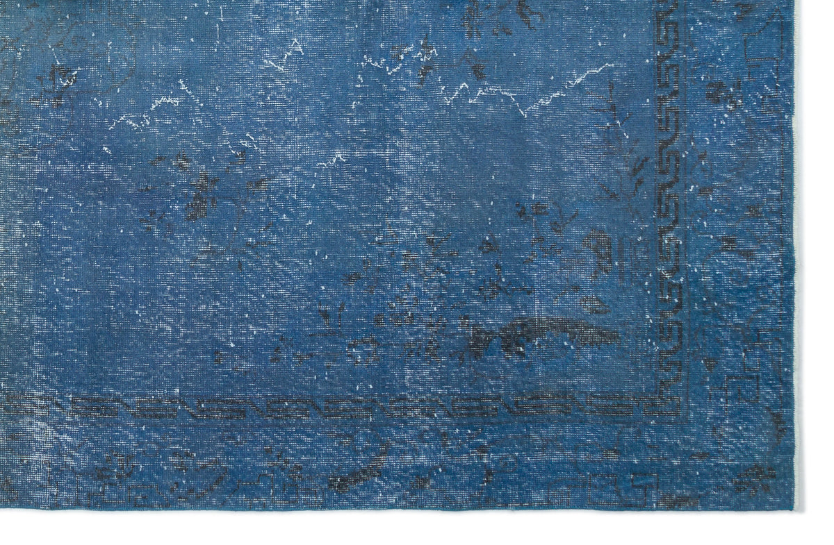 Distressed blue rug with a faded traditional pattern and a dark geometric border on a white background.