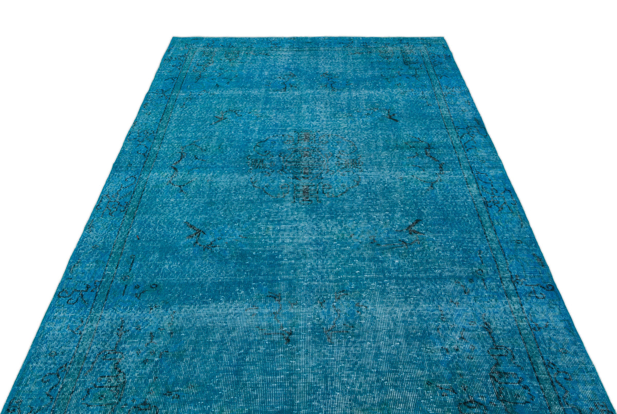 Bright blue distressed rug with a central medallion and dark linear border patterns on a white background.