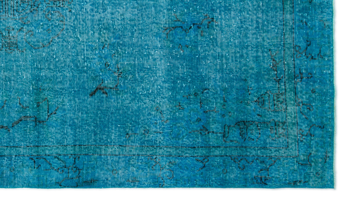 Bright turquoise distressed rug with a faded black linear border and sparse, worn-out traditional motifs.