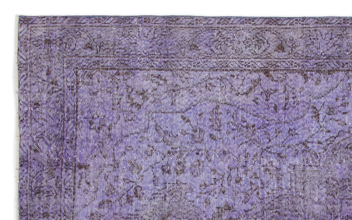 Distressed purple rug with a dark grey traditional floral border and central vine pattern.